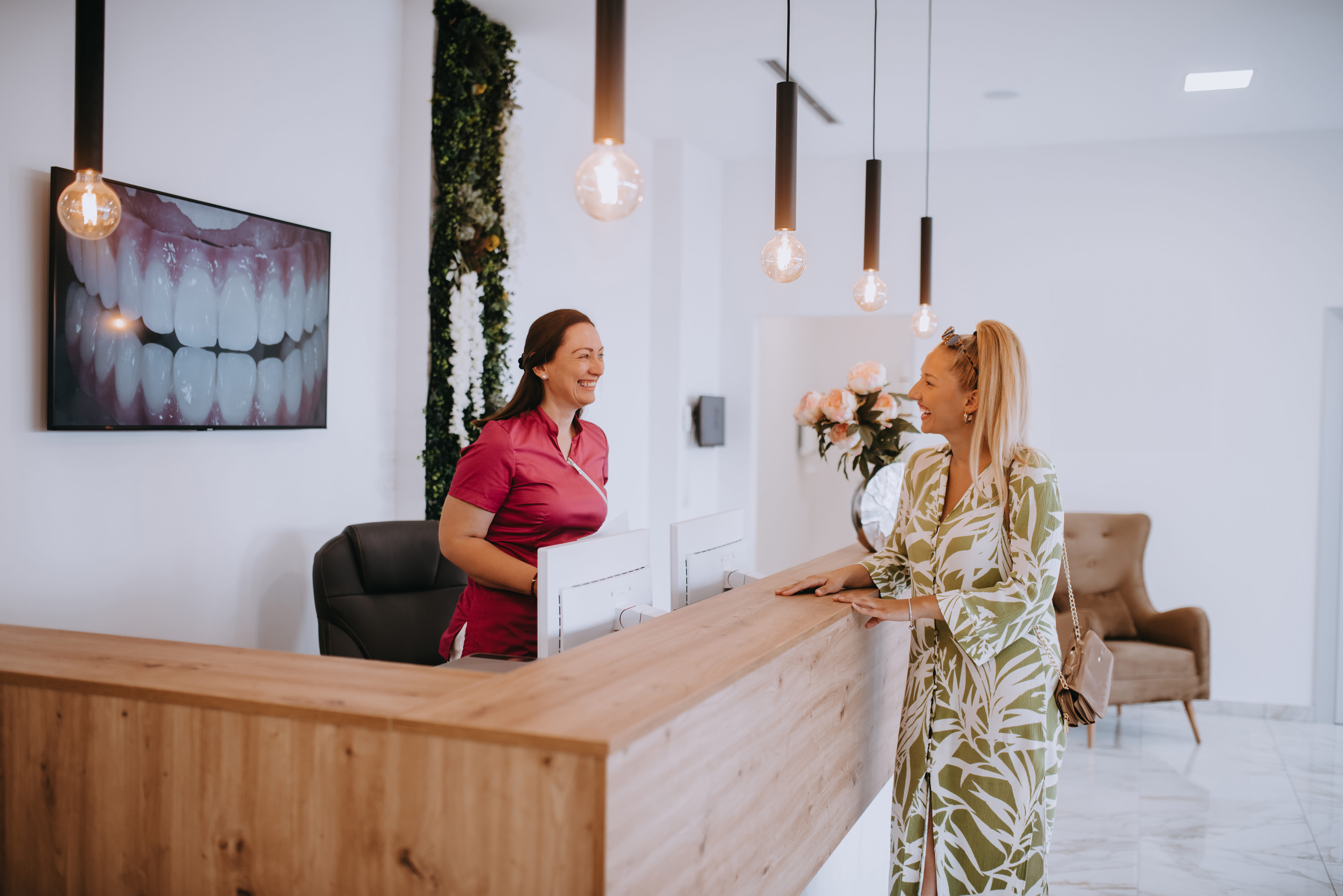 A dental office team member greeting a patient at the front desk