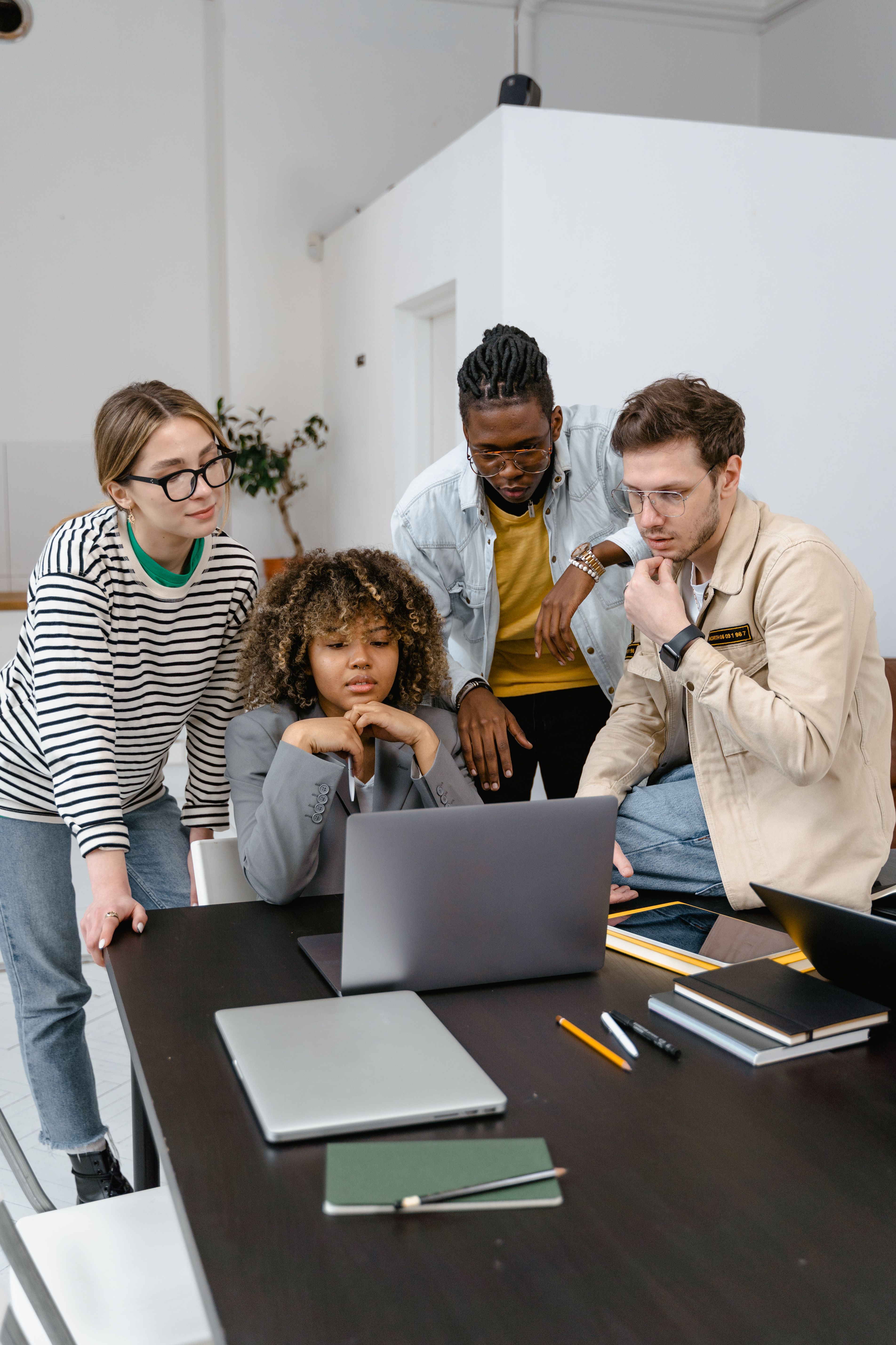 Employees working together around a laptop