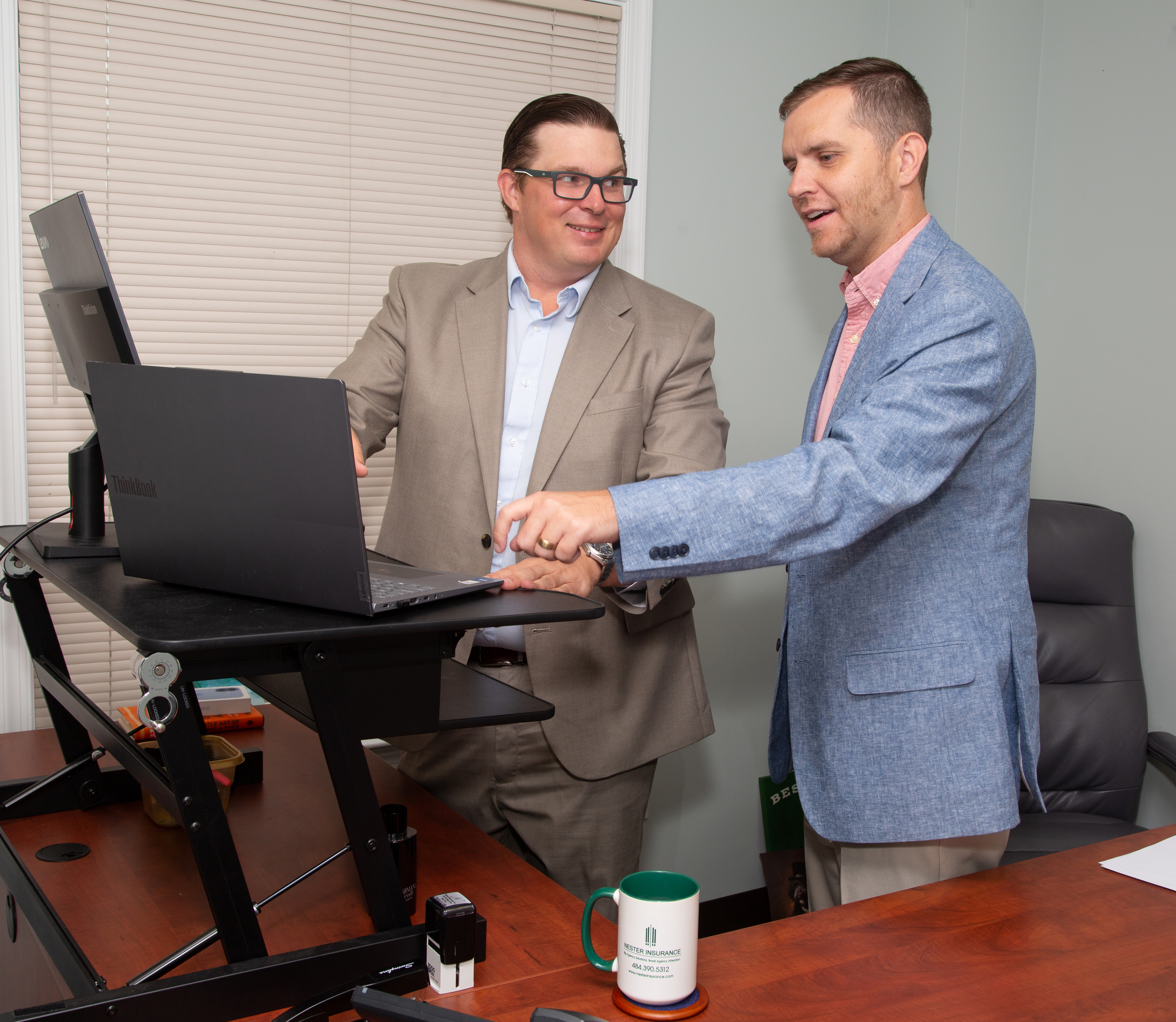 Nester Insurance team members reviewing work together on a monitor